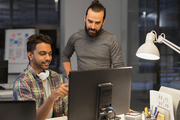Creative team with computer working late at office min