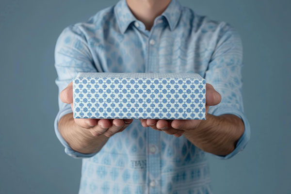 Man offering or received a white gift box with blue patterns min