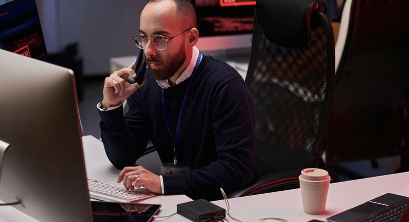 Man using computer with multiple monitors