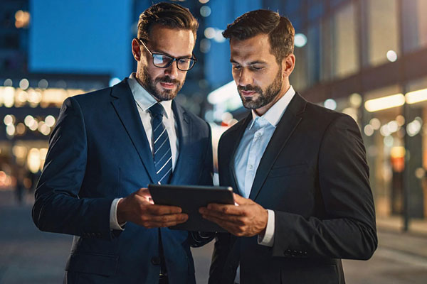 Two business partners looking at tablet min