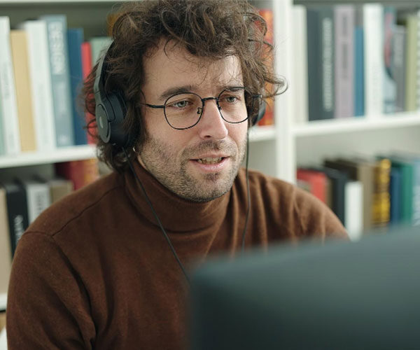 Young hispanic man student using computer and headphones studying