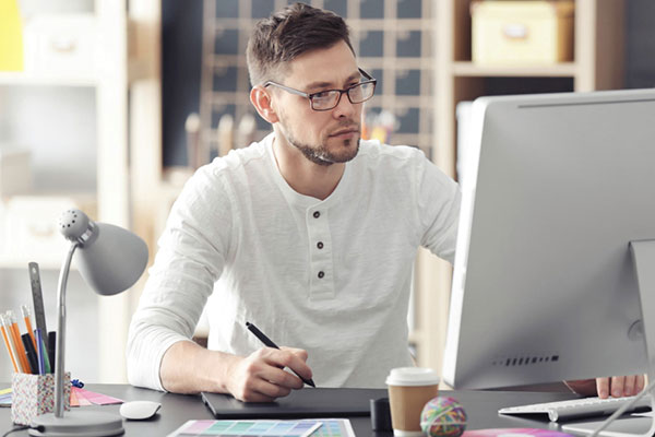Young male designer working in office min